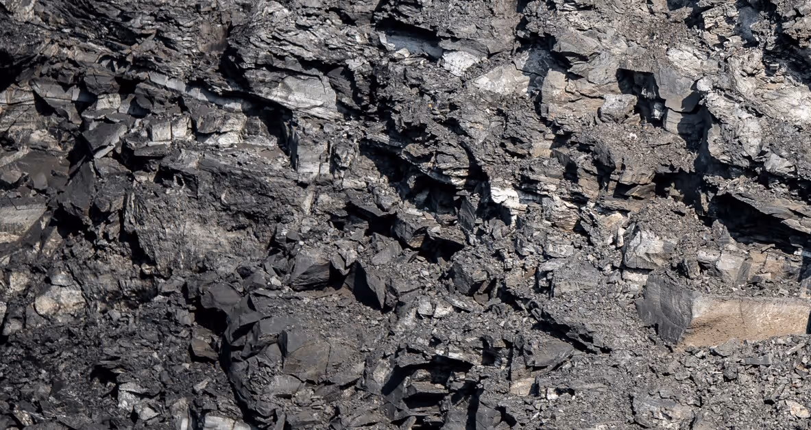 Dark rock and shale overburden from mining operations requiring specialized excavation support and overburden management