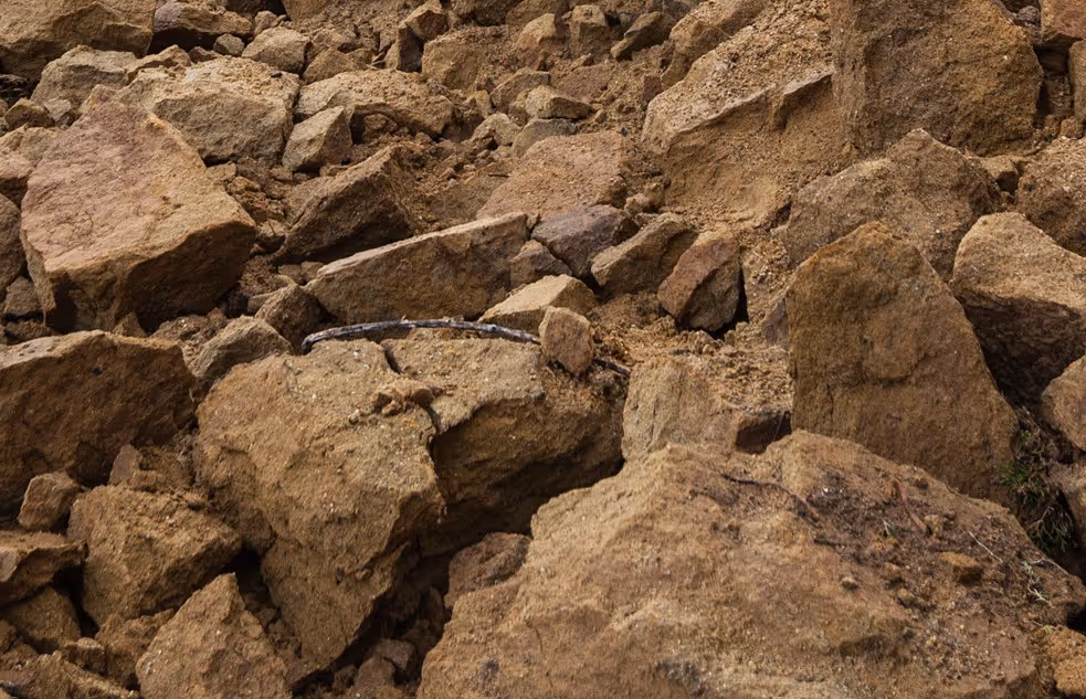 Large sandstone boulders and rock debris from landslide requiring specialized excavation support and geological stabilization
