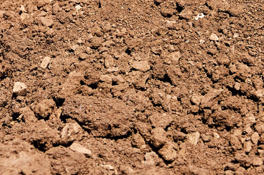 Excavated clay and rocky soil from utility trench digging requiring specialized trench excavation and backfill services