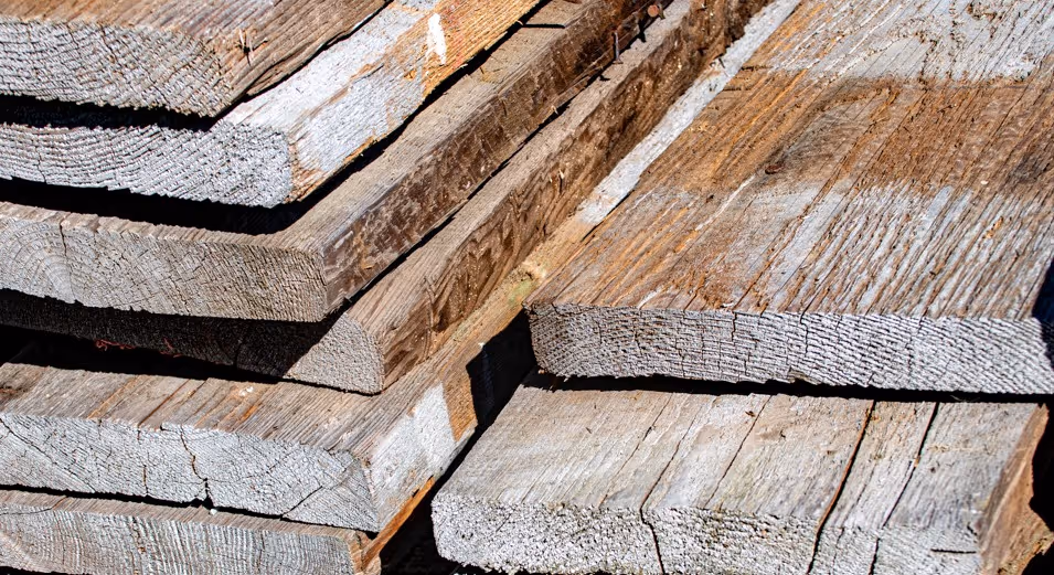 Weathered reclaimed lumber and salvaged wood planks requiring specialized forestry product transport and delivery