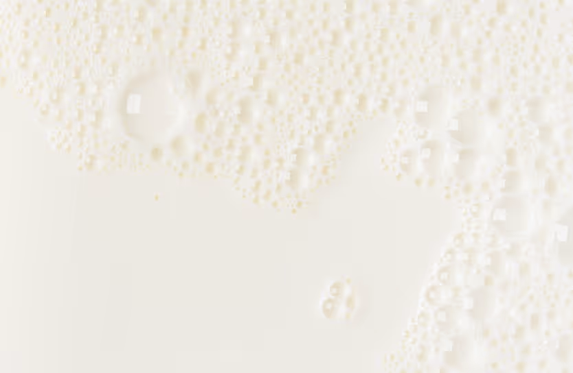 Fresh milk with cream bubbles and dairy foam requiring specialized bulk dairy hauling and food-grade liquid transport services