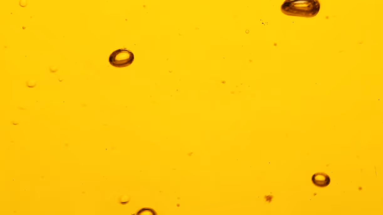 Golden cooking oil with bubbles and food-grade edible oil requiring specialized bulk edible oil hauling and transport services