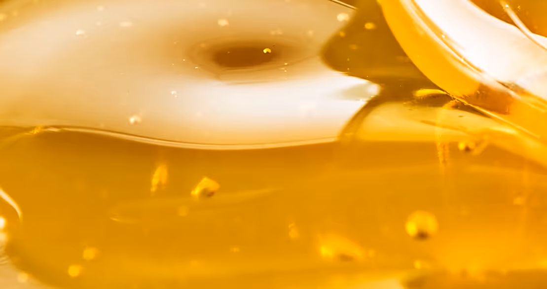 Pure liquid honey and golden sweetener with natural viscosity requiring specialized food-grade sweetener hauling services