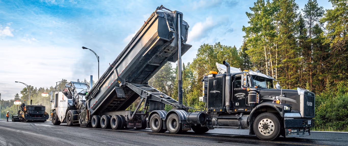 Black semi-trailer end dump truck for large-scale commercial hauling and heavy construction material transport