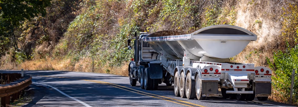White side dump truck with pneumatic trailer for specialized material hauling and commercial transport services