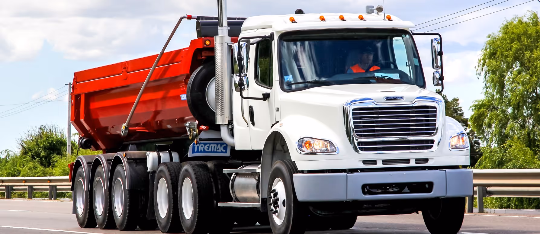 White quint axle dump truck for maximum capacity commercial hauling and heavy construction material transport