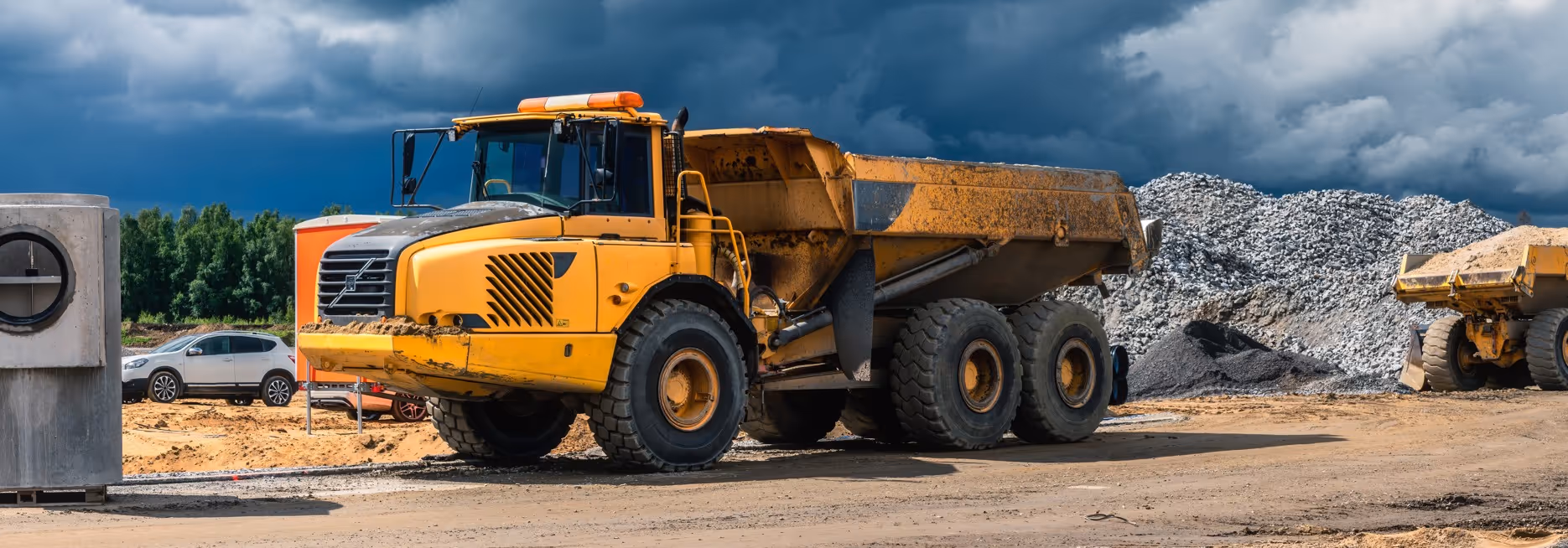 Yellow articulated dump truck for off-road commercial hauling and rough terrain material transport services
