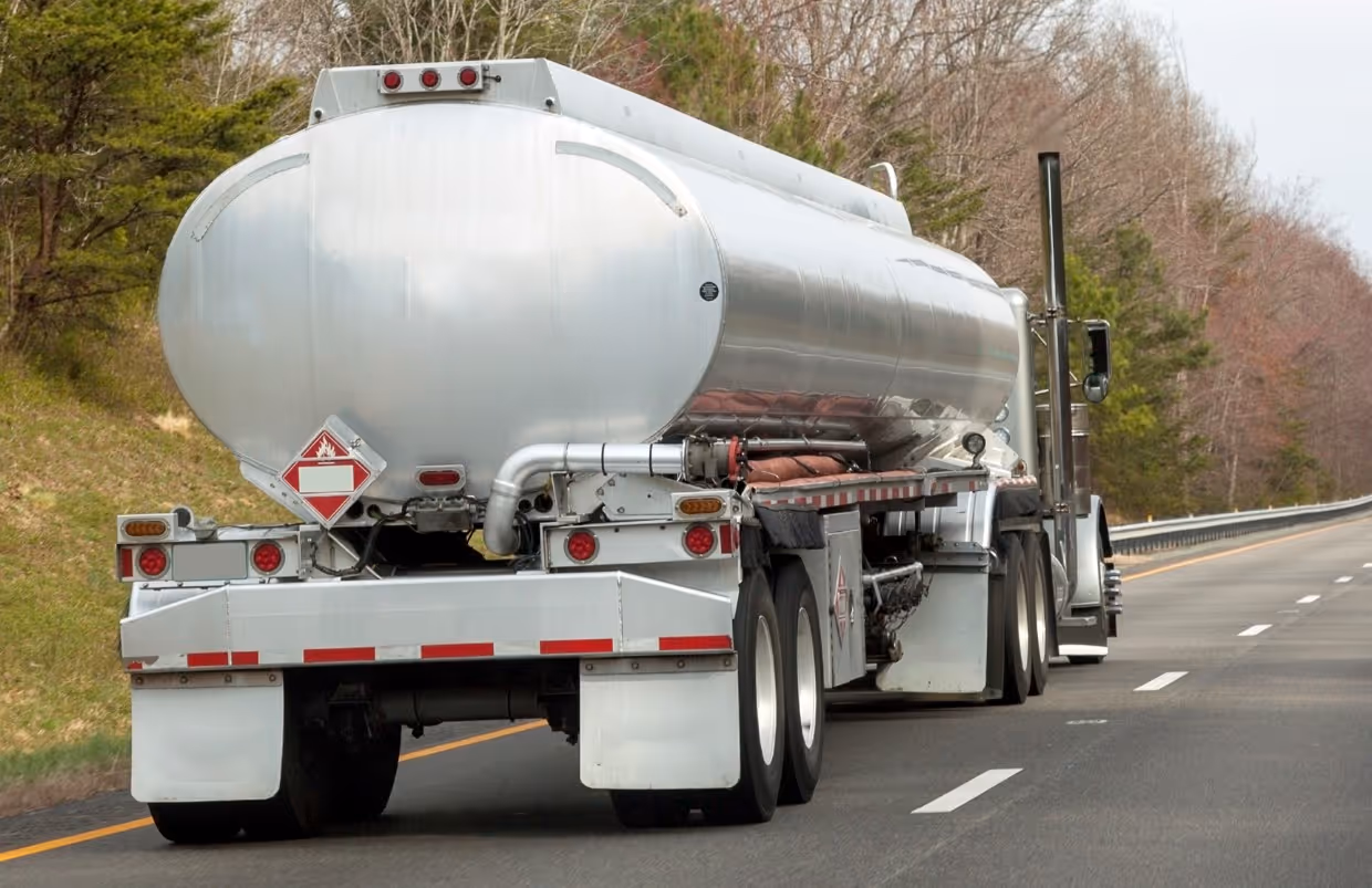 White tanker truck with hazmat placards for liquid transport and commercial fuel hauling services
