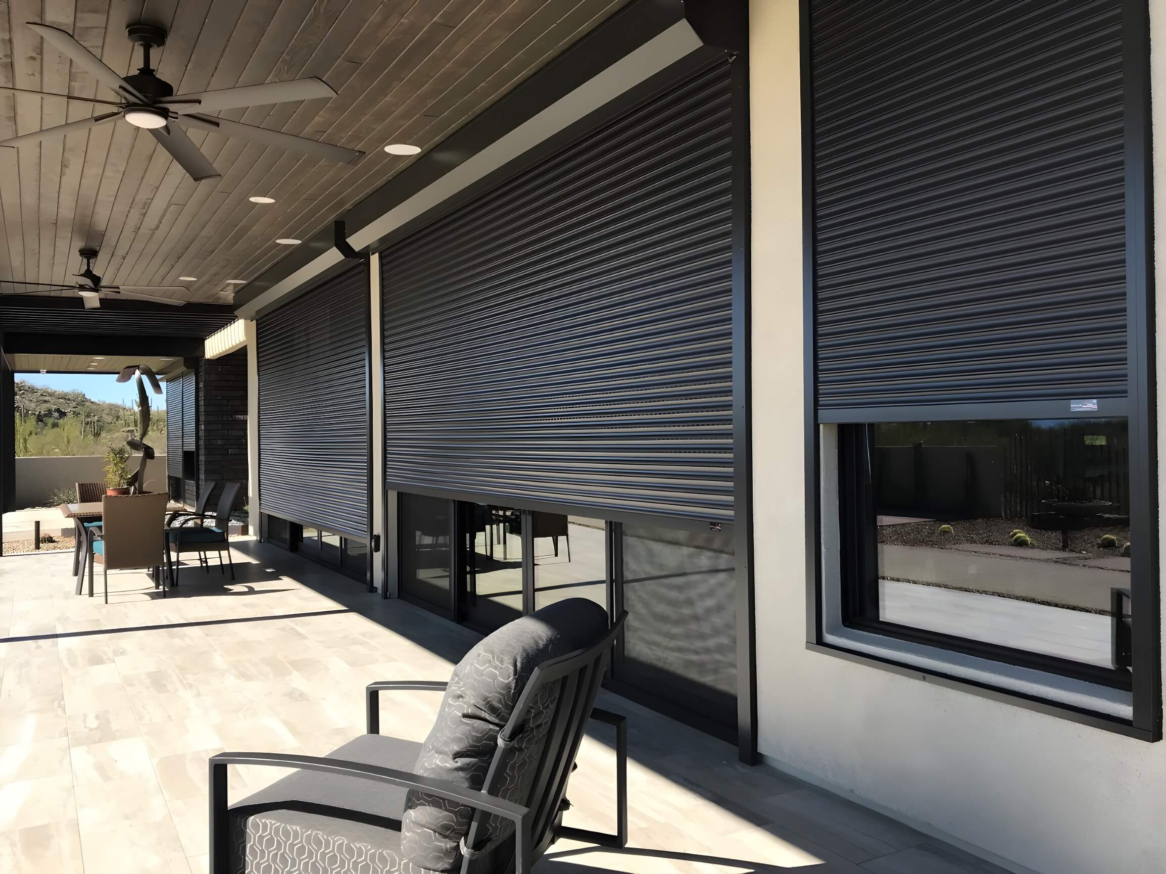 Rolling shutters partially deployed covering sliding glass door and glass windows 