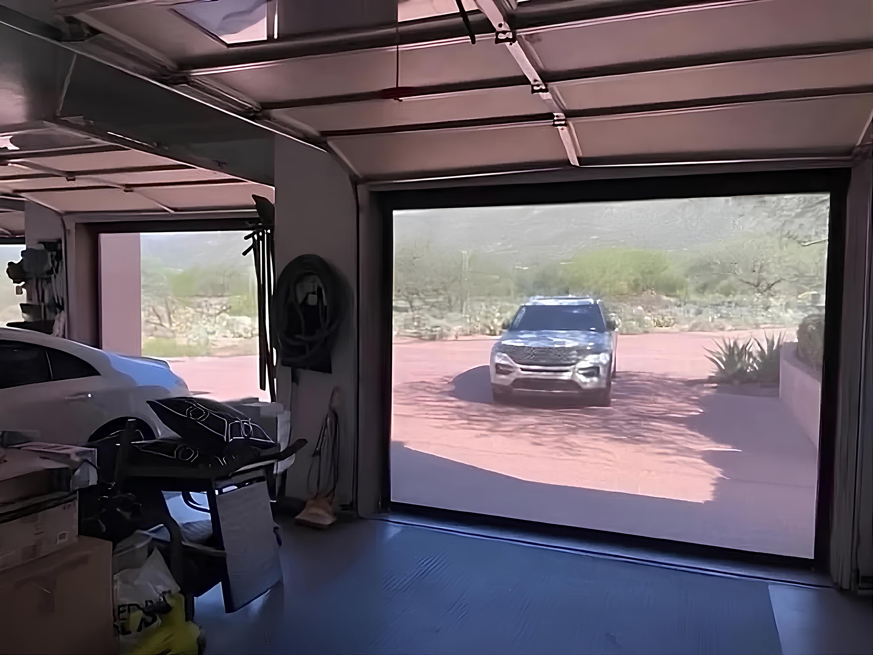 Garage with motorized screen showing outside view.
