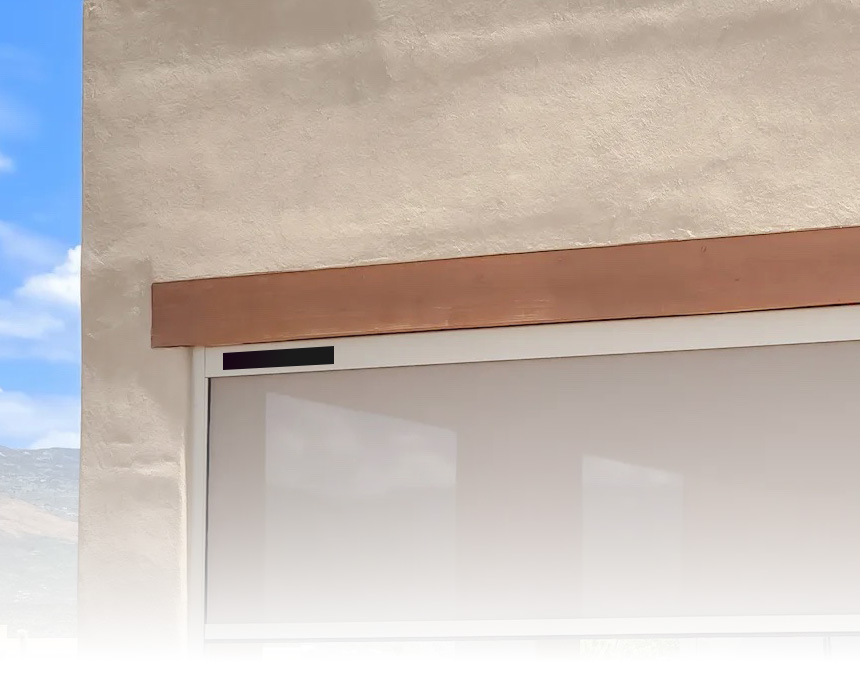Solar-powered automatic garage door opener mounted above a garage door on a beige stucco wall.