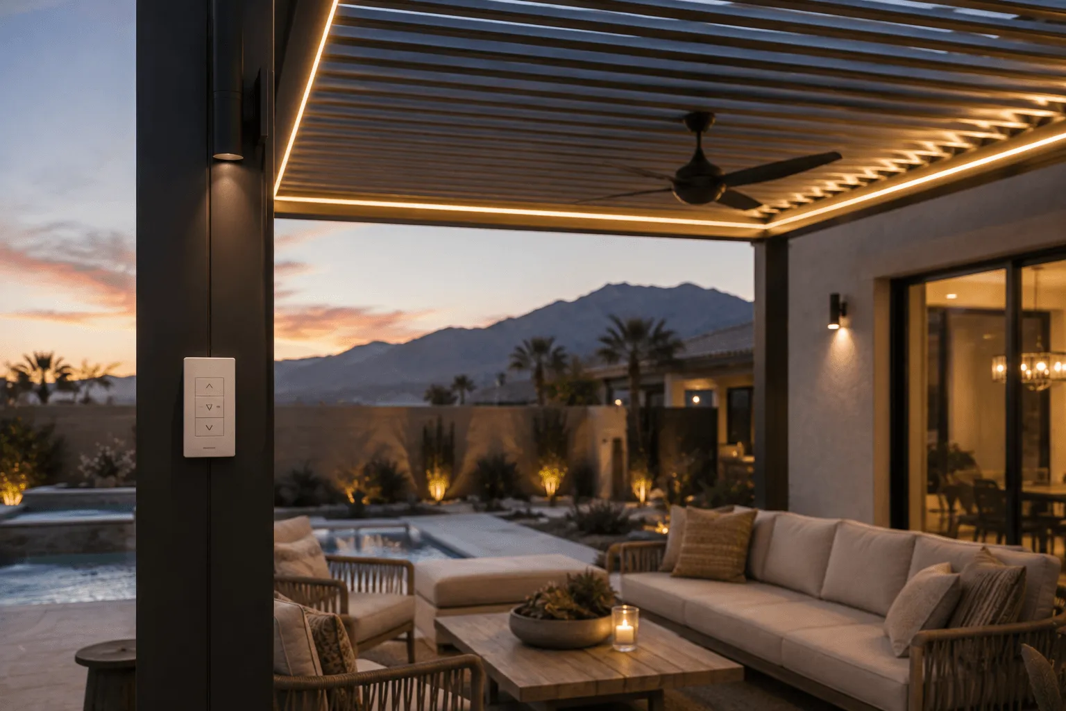 Pergola with integrated LED strip lighting and a ceiling fan over a poolside lounge area at sunset