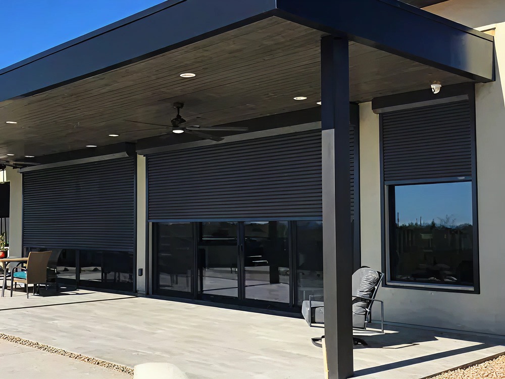 Motorized rolling shutters partially lowered over patio doors and windows