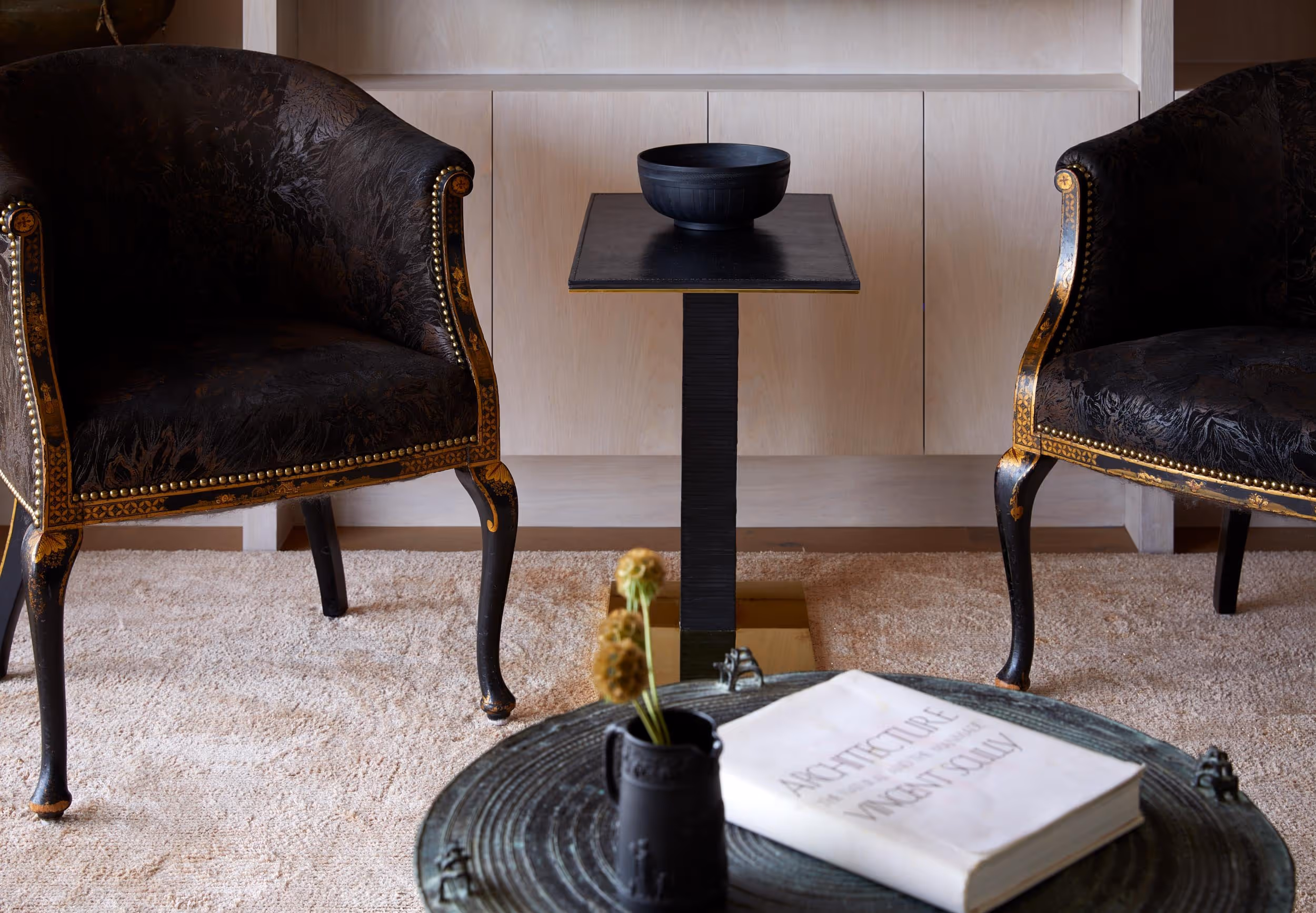 2 ornate chairs with mini table in between