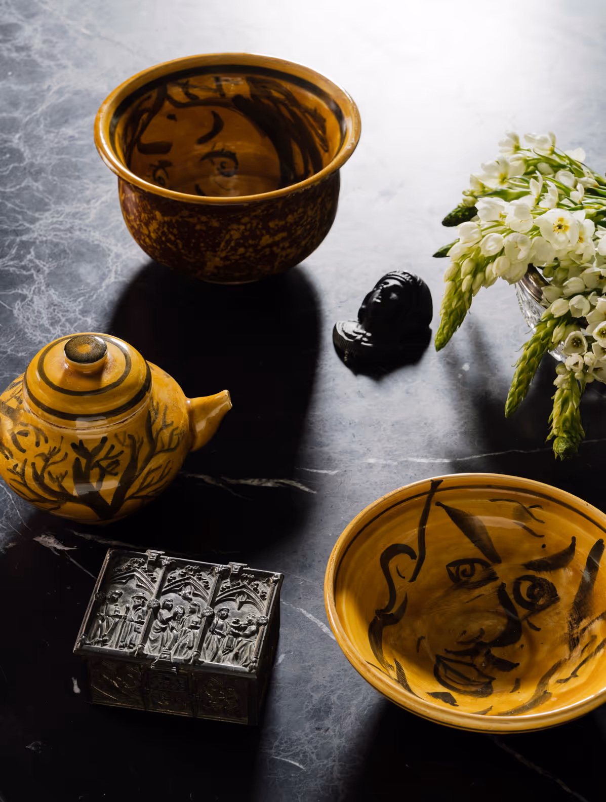 Yellow and black tea set on a black table
