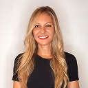 Smiling woman with long blonde hair wearing a black shirt against a white background.