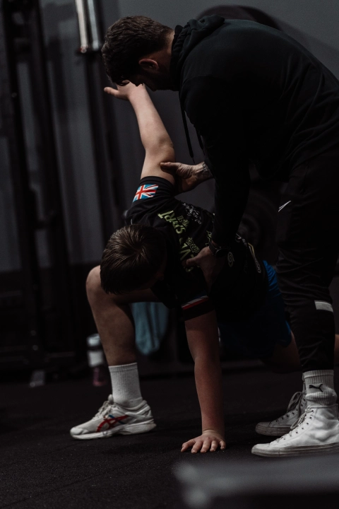 A man performs squats in a gym, showcasing strength training at Unity Personal Training in Grays, ENG.