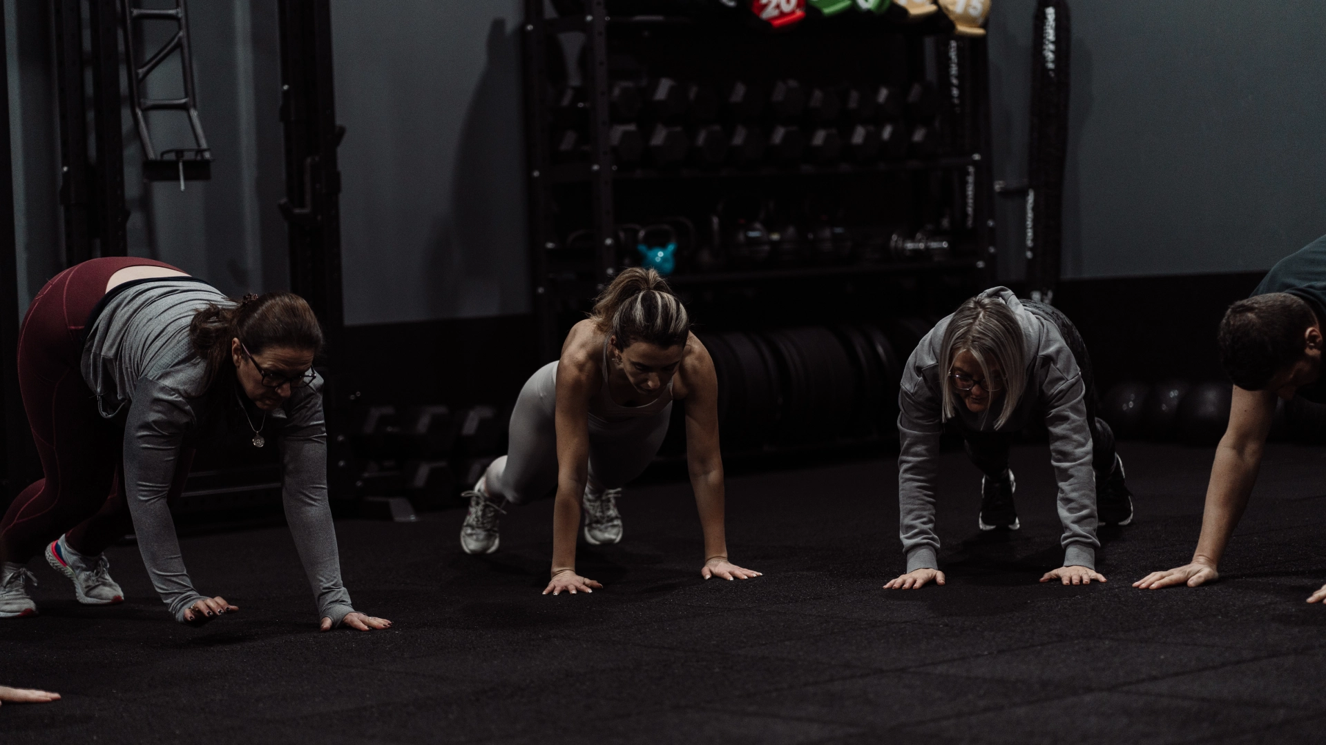 A group of individuals performing push-ups in a gym during a Team Strength & Conditioning session at Unity Personal Training, Grays.