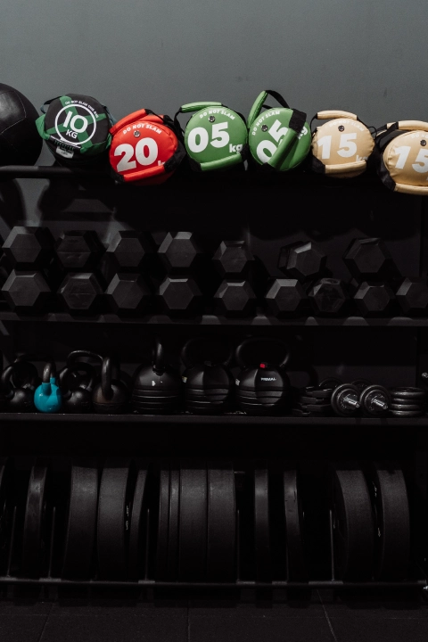 A black rack displaying various weights and dumbbells at Unity Personal Training in Grays, ENG.