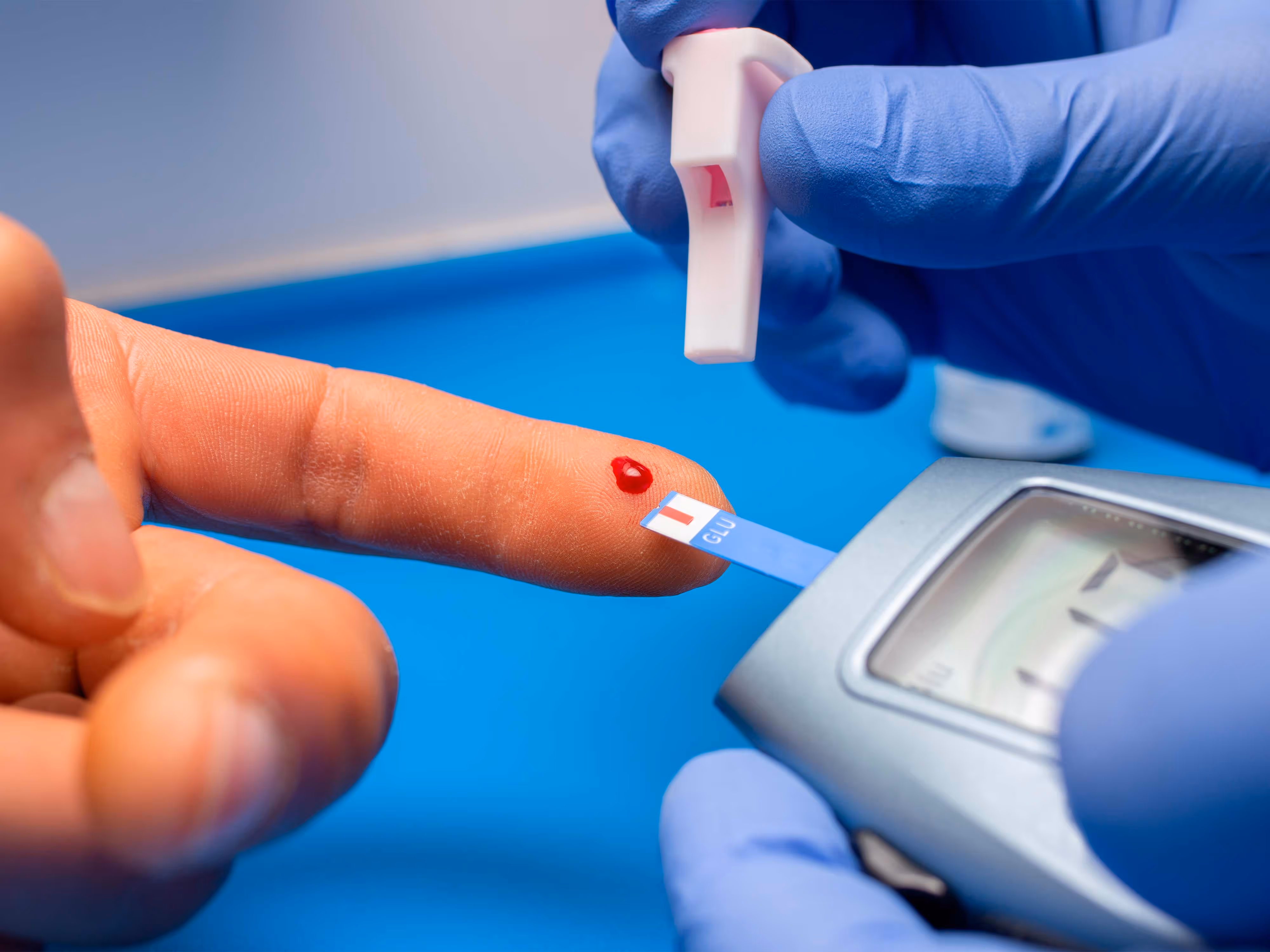 Dedo con una gota de sangre por una prueba de glucosa