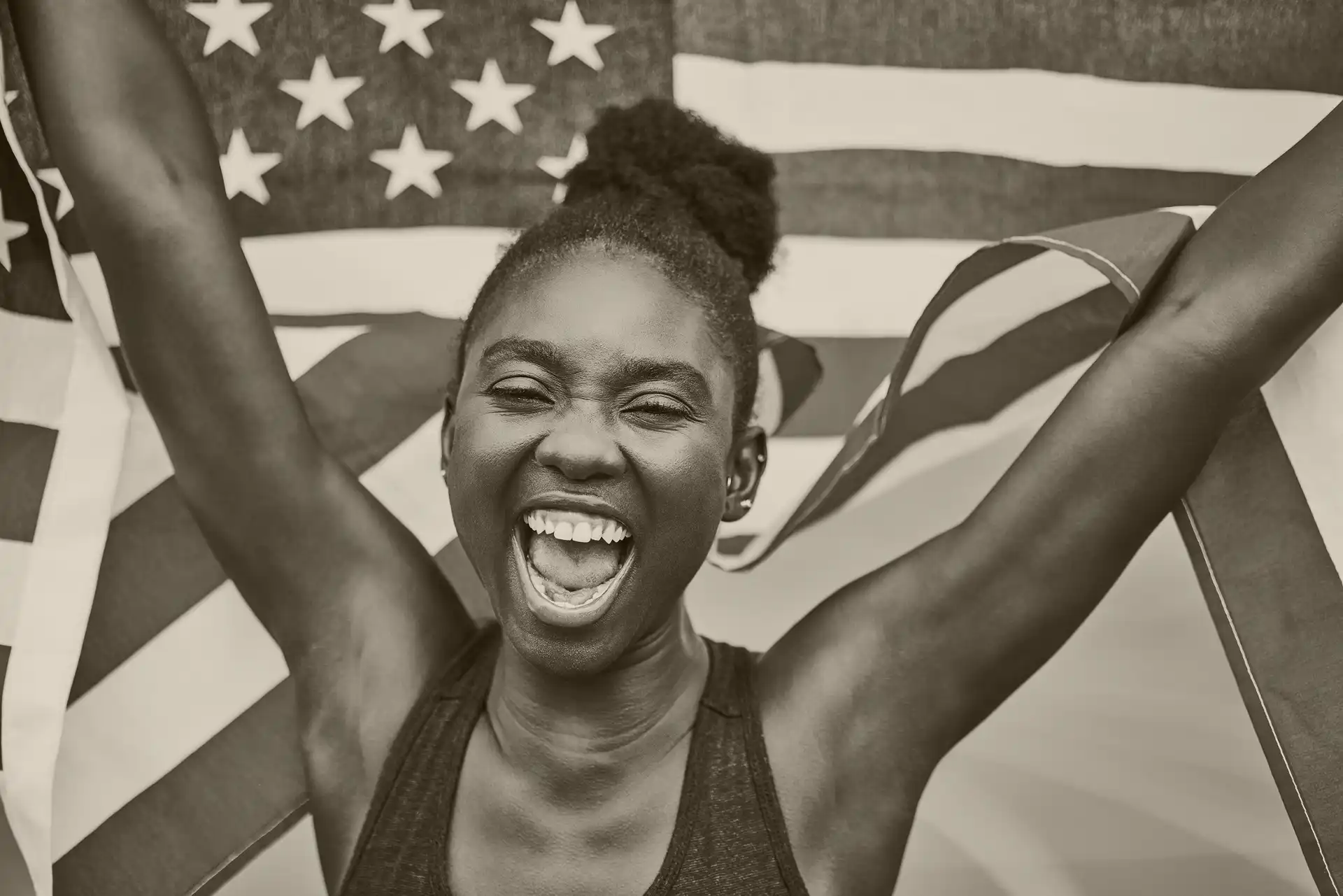 A black woman running a race while holding the United States flag
