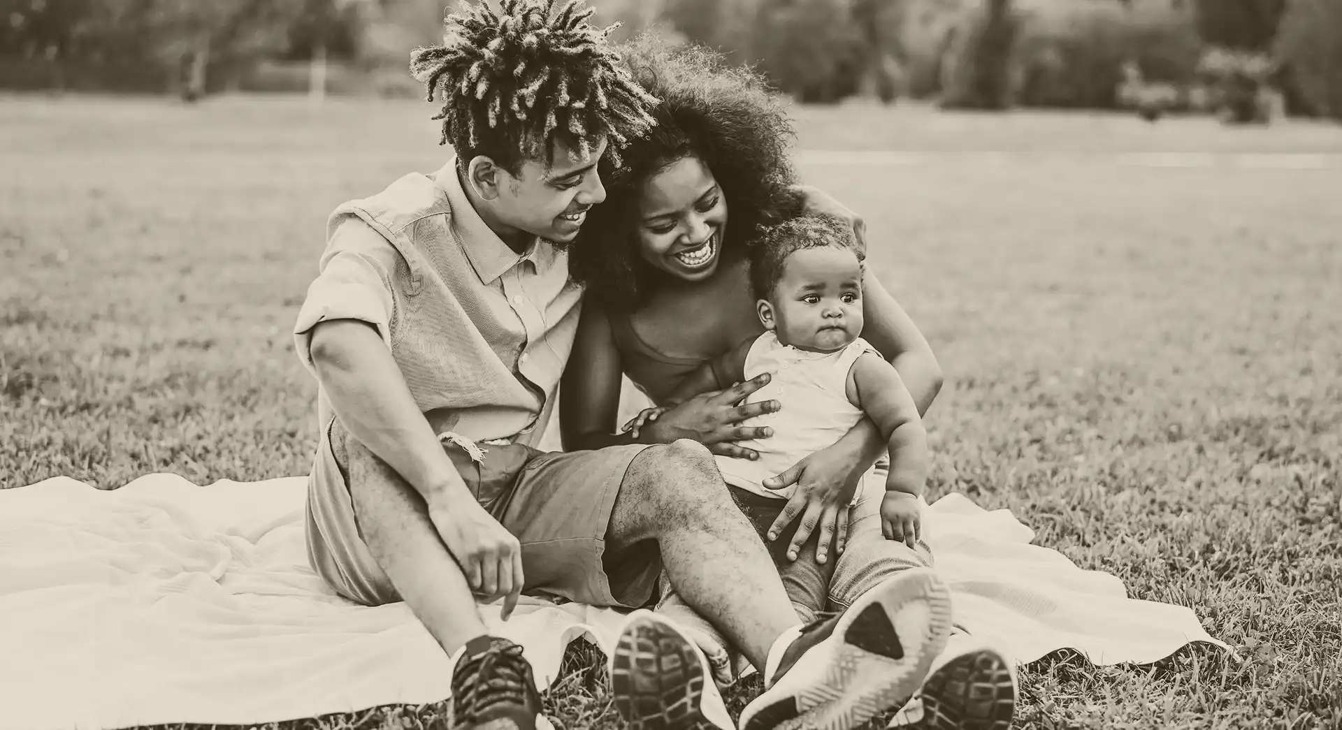 Young Black family sharing a meal and bonding at a park picnic