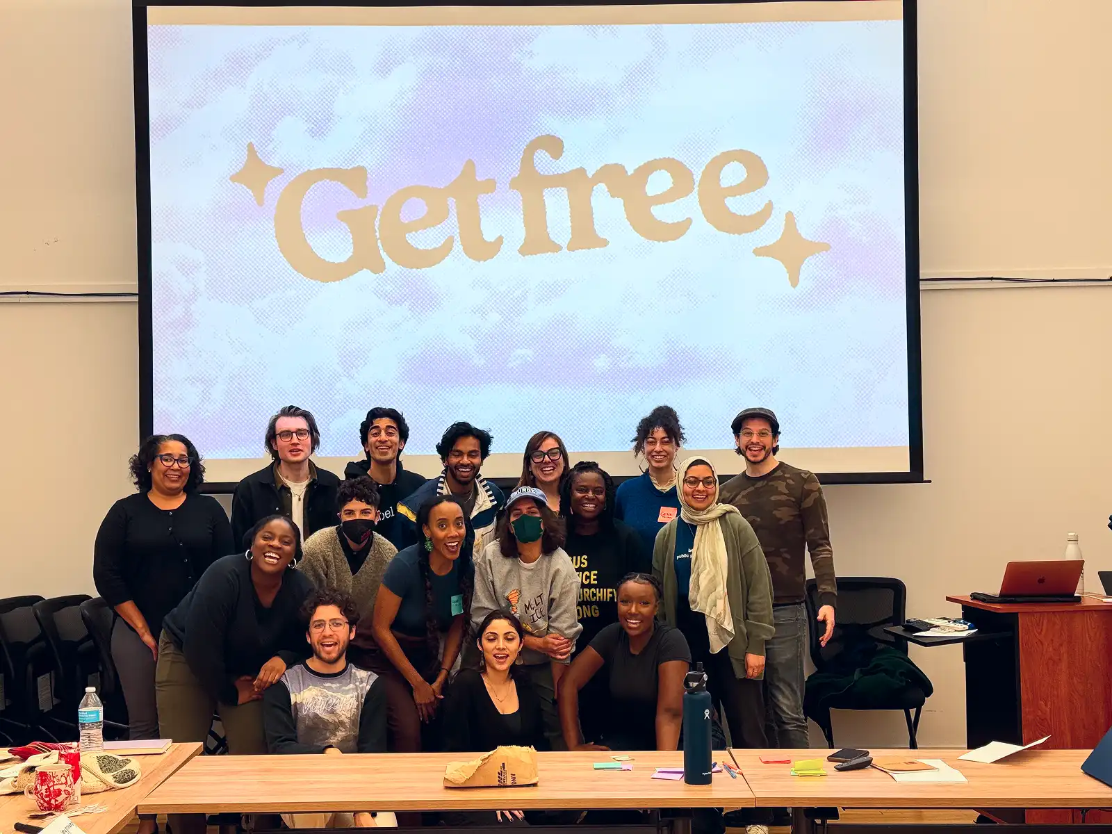 A group of students in Berkeley with the BUSD Reparations Coalition standing in front of a screen that says Get Free