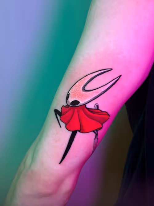 Hornet from Hollow Knight tattoo with red cloak on forearm