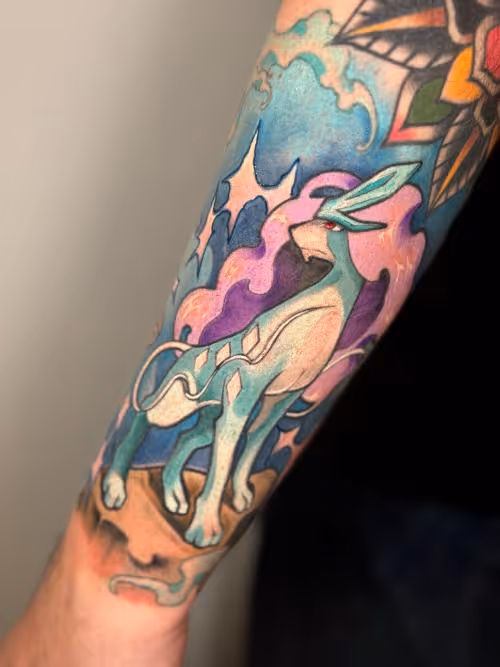 Colorful forearm tattoo of Suicune Pokémon with clouds and stars