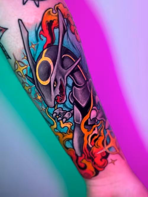 Colorful dragon tattoo with flames and electric accents on a forearm against a pink-green gradient background.