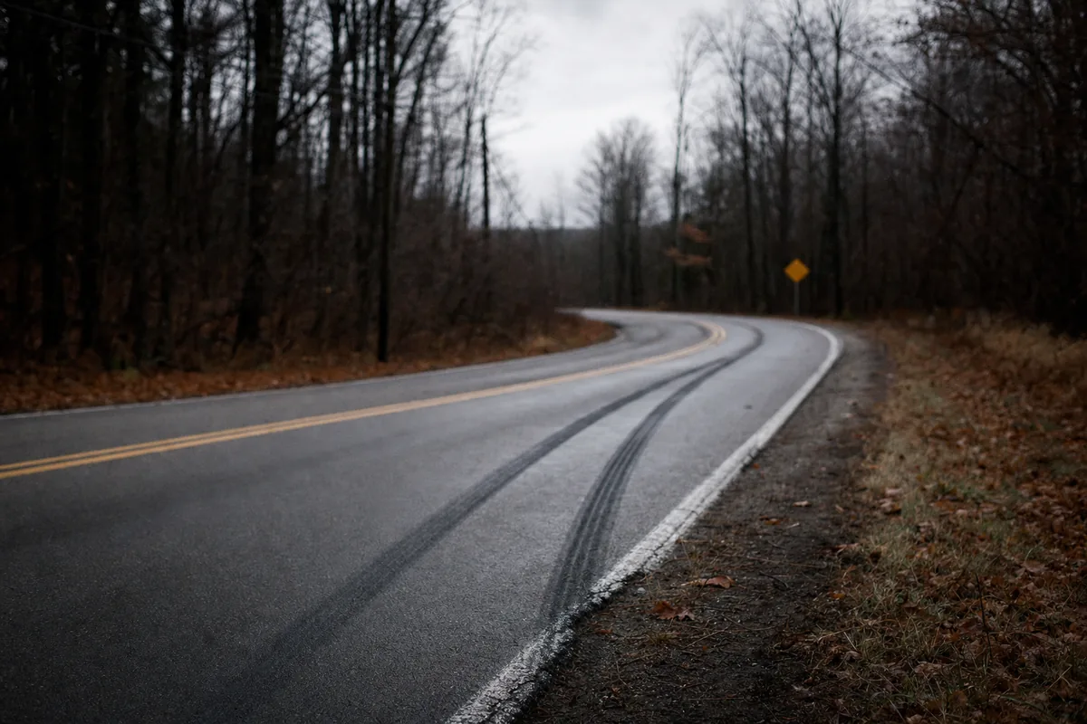 Curving rural Michigan two-lane road with long skid marks in autumn
