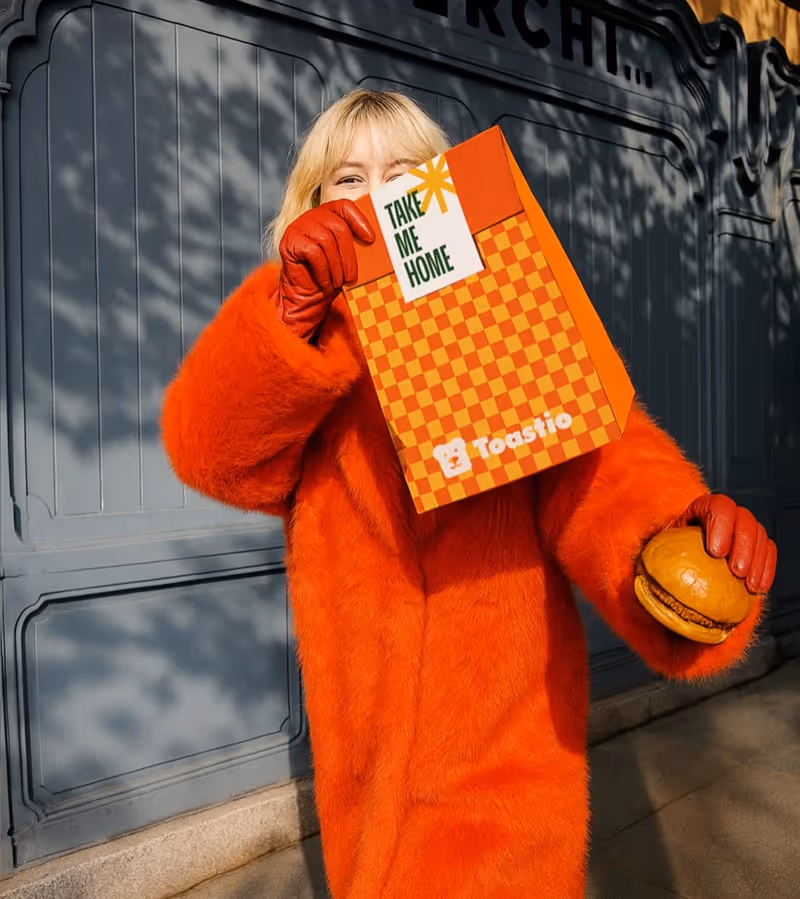 Photo of a lady holding a Toastio bag and bruger