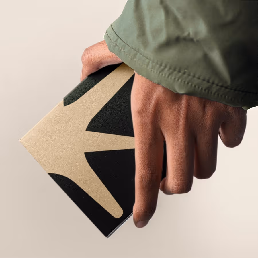 A hand holding a stylish, minimalist black and beige box with bold graphic design, reflecting modern branding and premium packaging aesthetics.