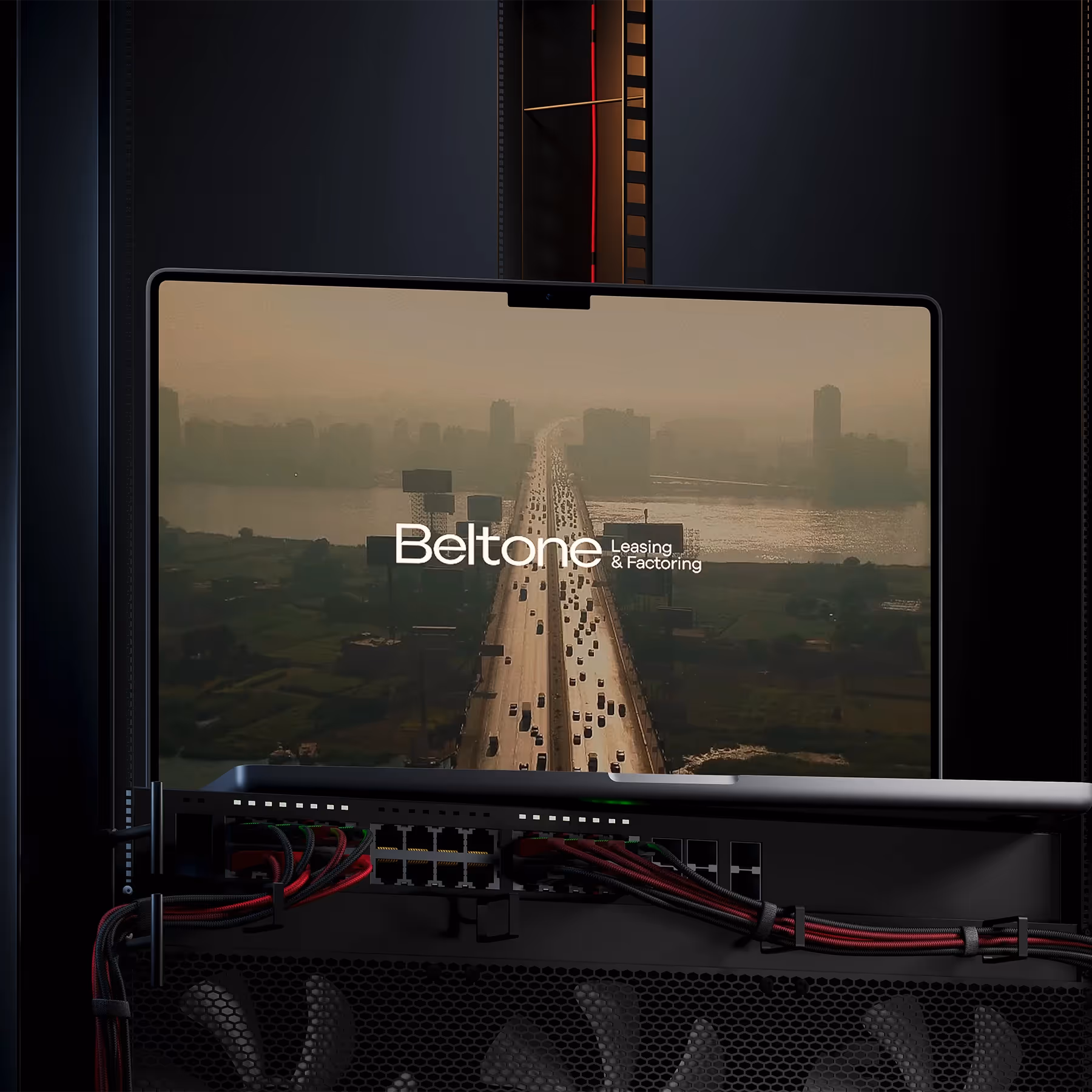 Computer monitor showing a hazy city highway with “Beltone Leasing & Factoring,” cables below hinting at a post-production setup.