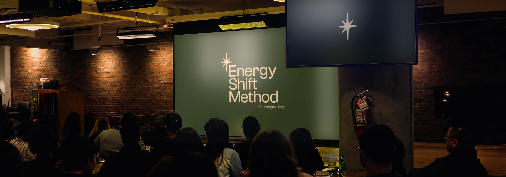 Mockup of an audience watching a screen on standby that has Energy Shift Method's branding and emblem