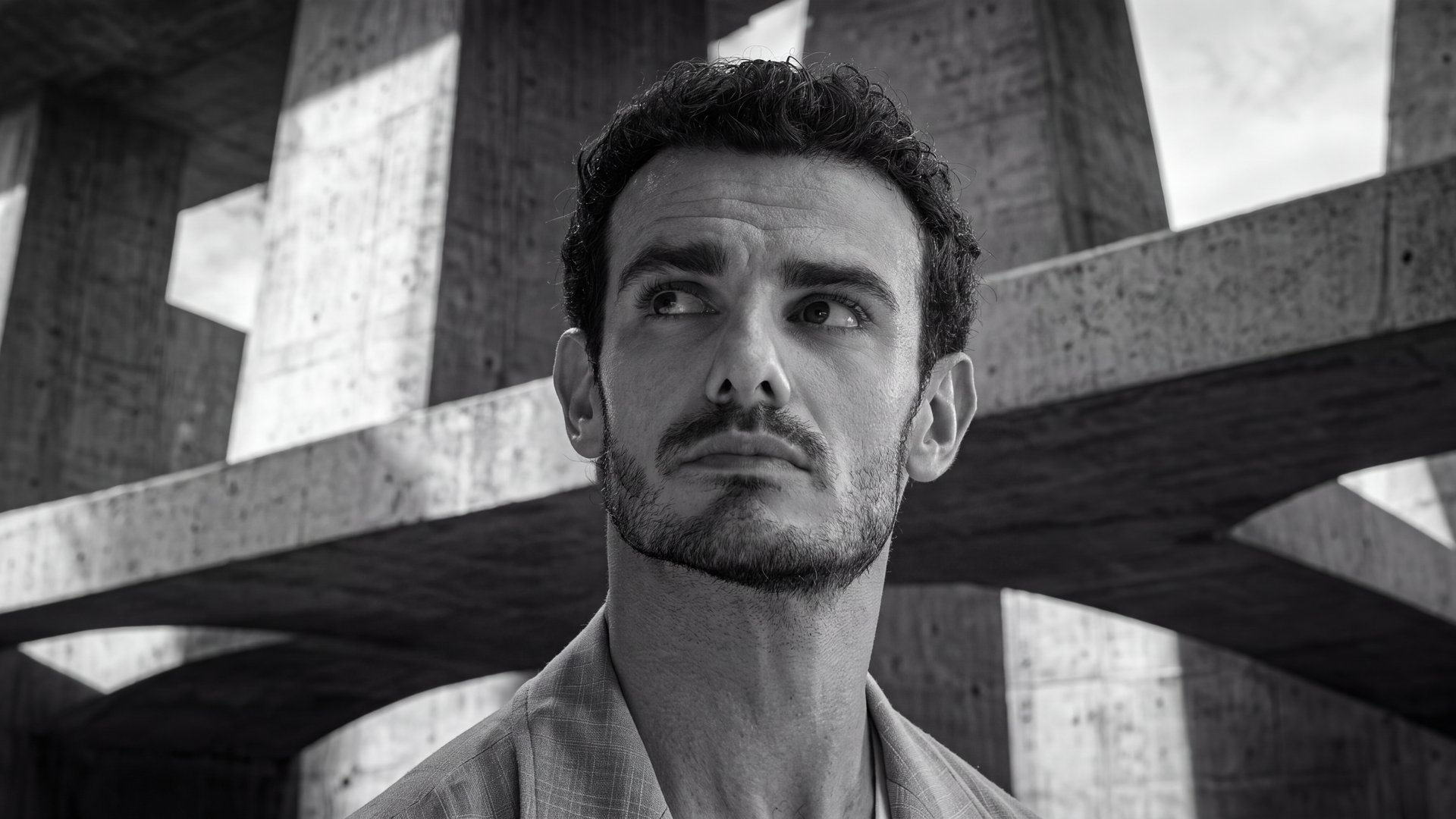 Man looking up beneath crossing concrete beams