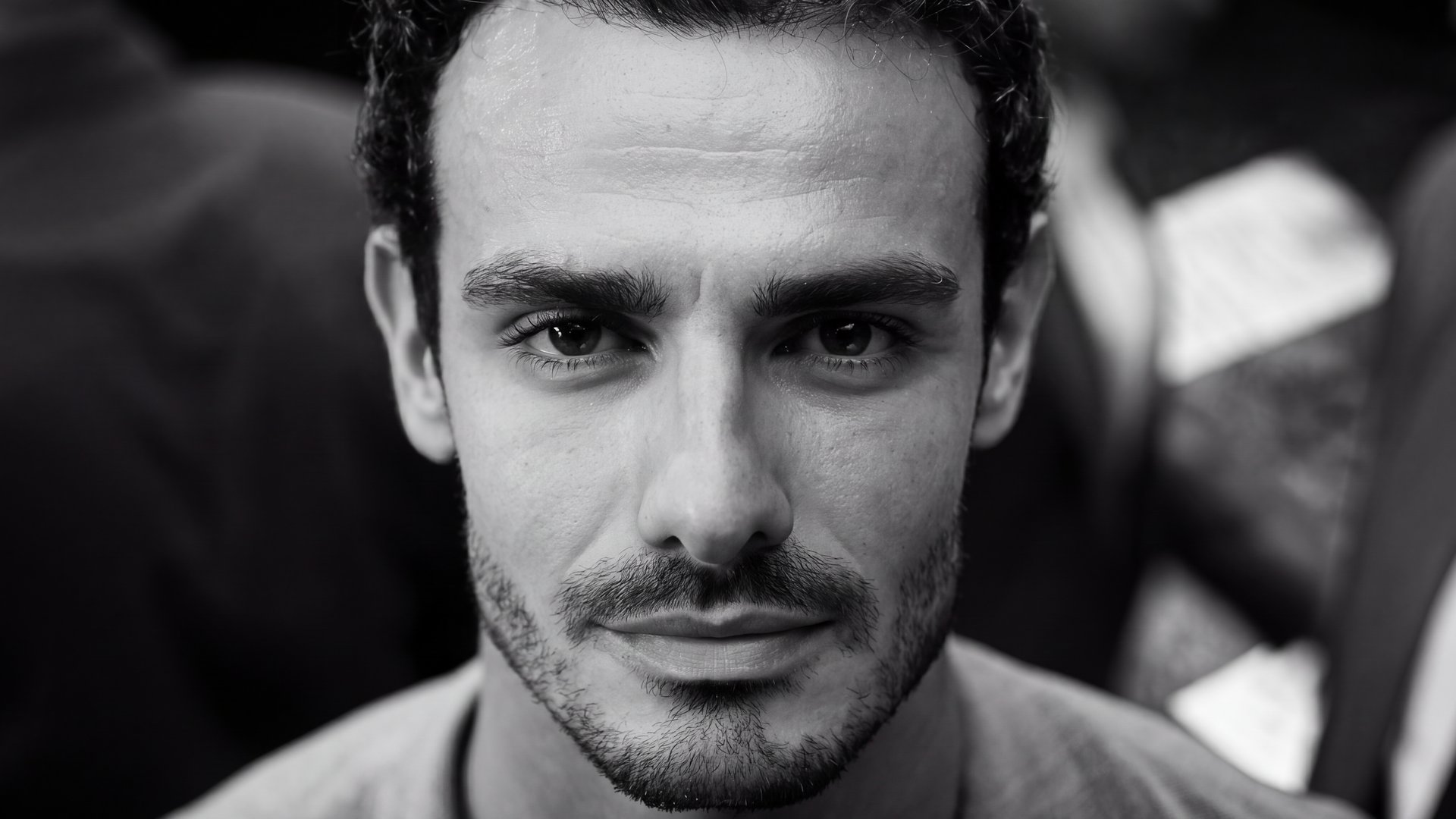 Black and white close-up portrait against a blurred crowd