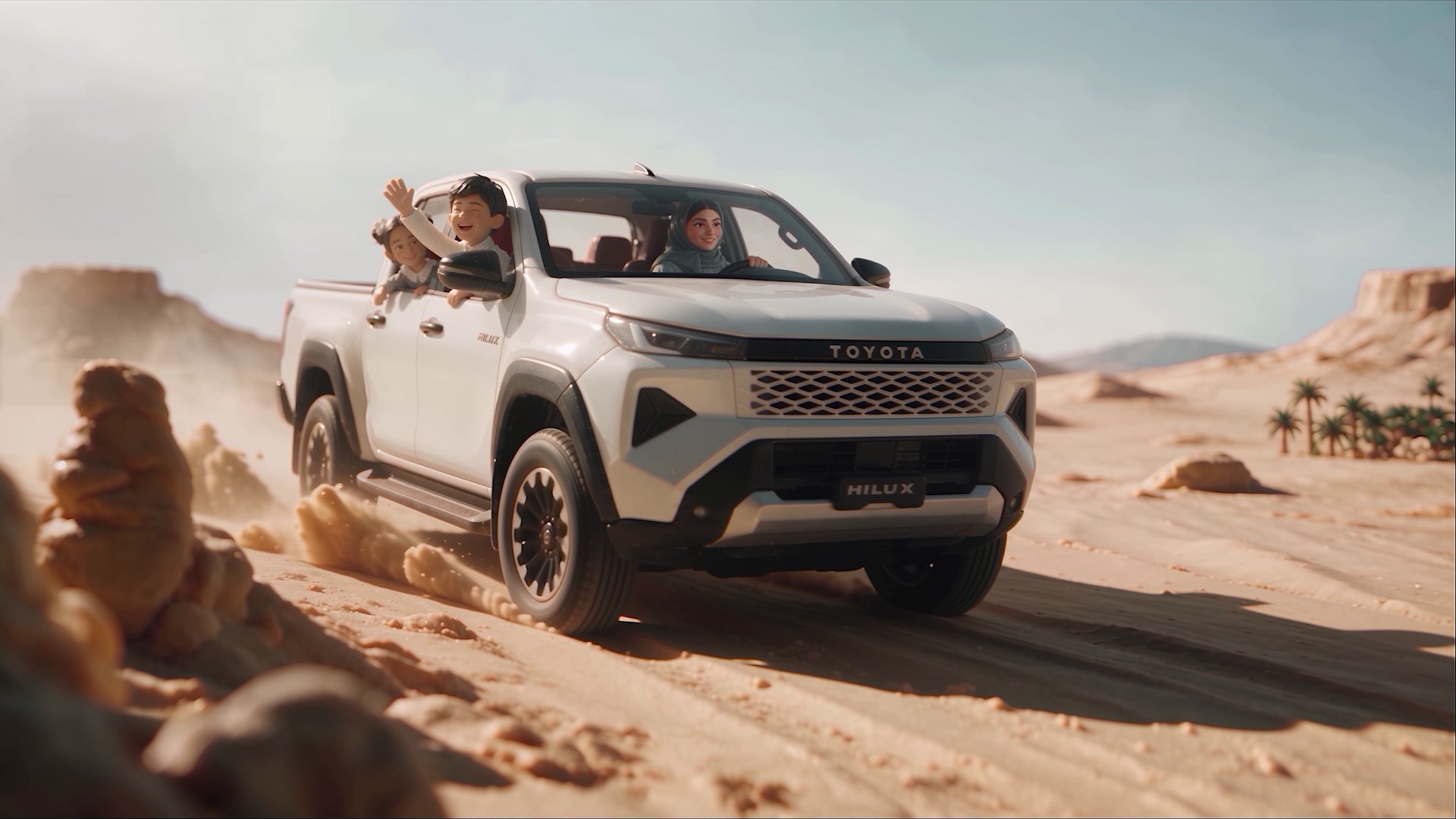 Toyota Hilux kicking up sand in the desert with children riding in the back