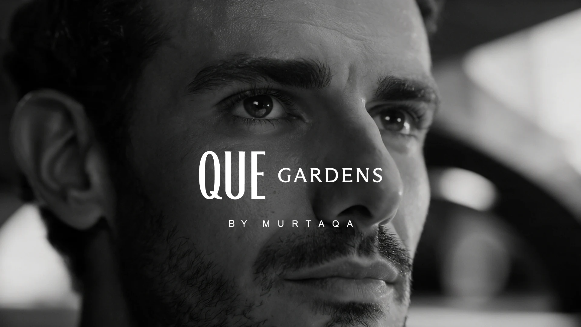 Que Gardens by Murtaqa title card over a black and white close-up of the campaign lead