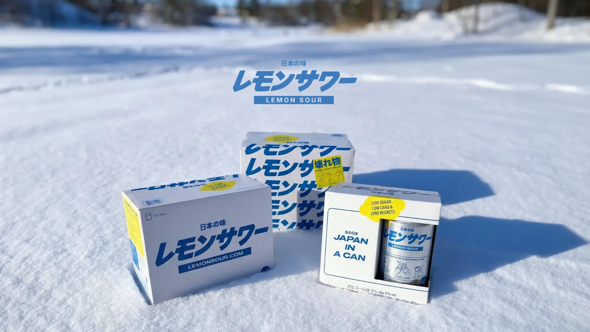 Three Lemon Sour packs standing in fresh snow under the Lemon Sour logo