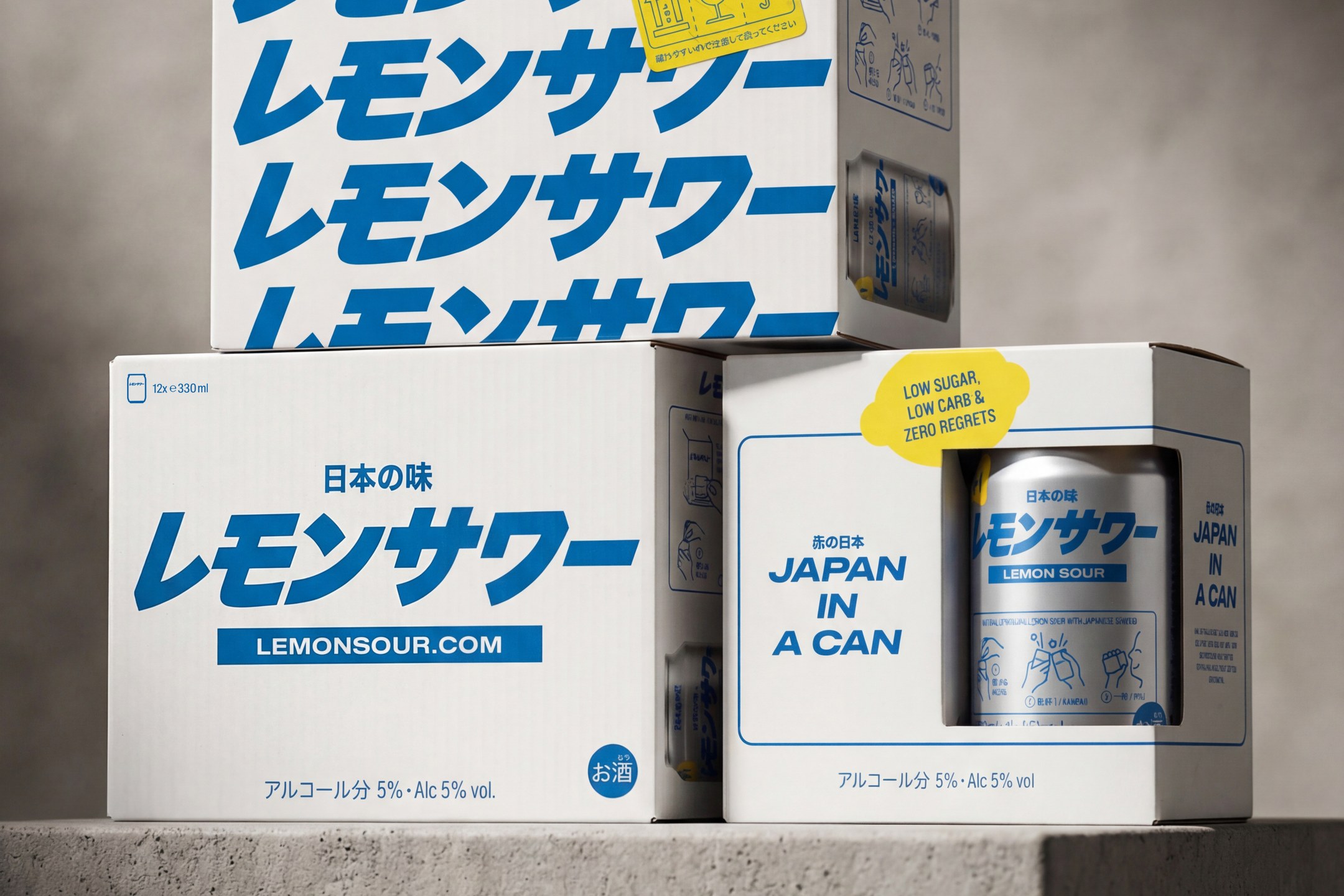 Lemon Sour case boxes and gift pack stacked on a concrete plinth