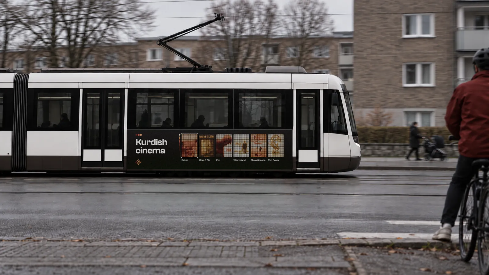 A tram carrying a Kardo advertisement passes through a city street