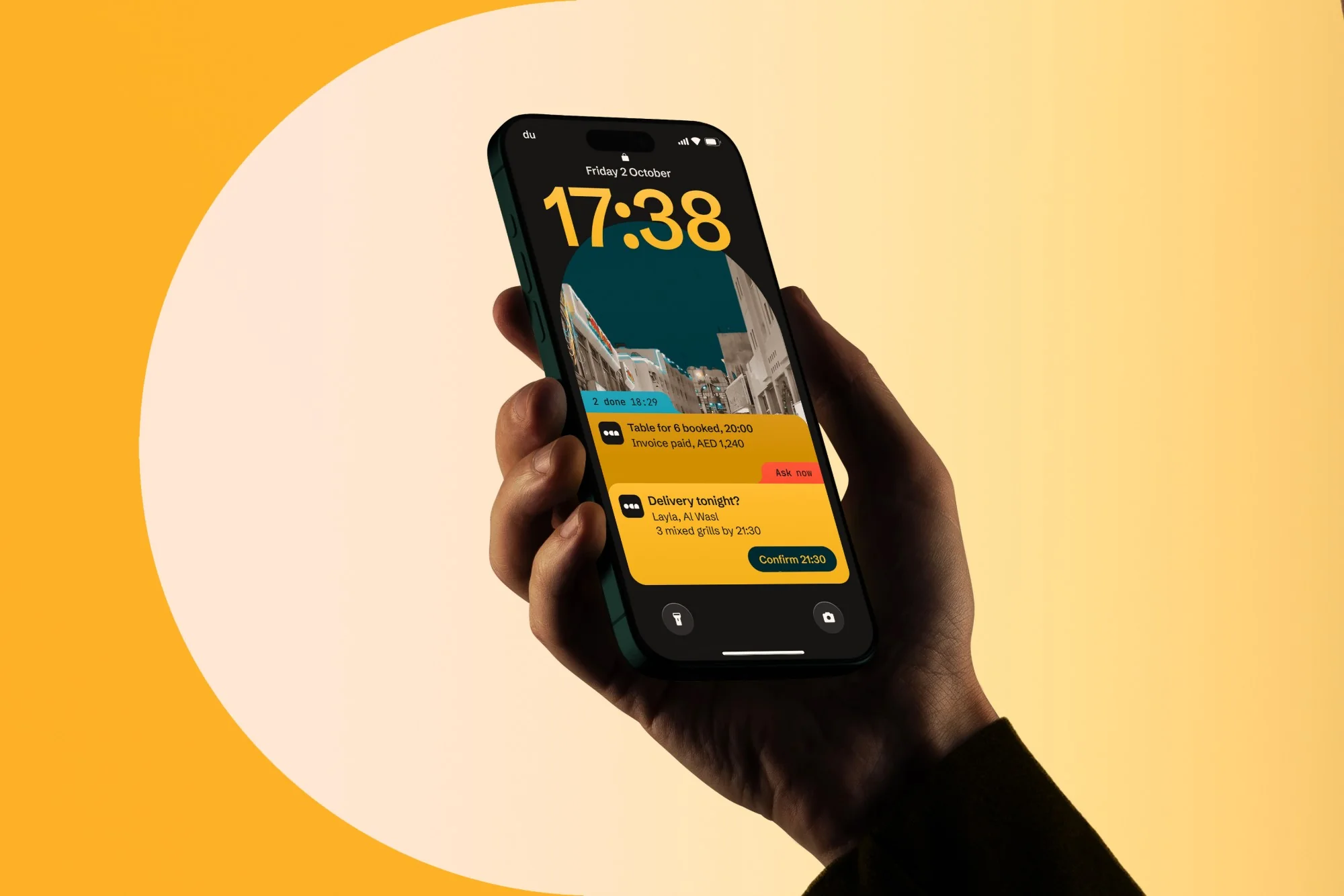A hand raising a phone whose lock screen shows the evening's orders