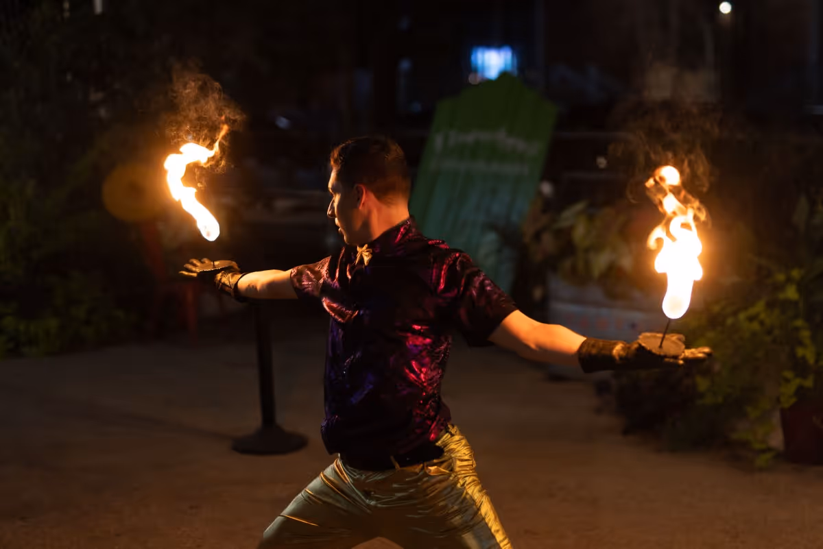 Fire performer juggling flames at night with dramatic lighting