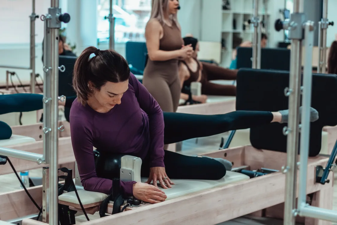 Instructor teaching class of Reformer Pilates at Workshop Pilates