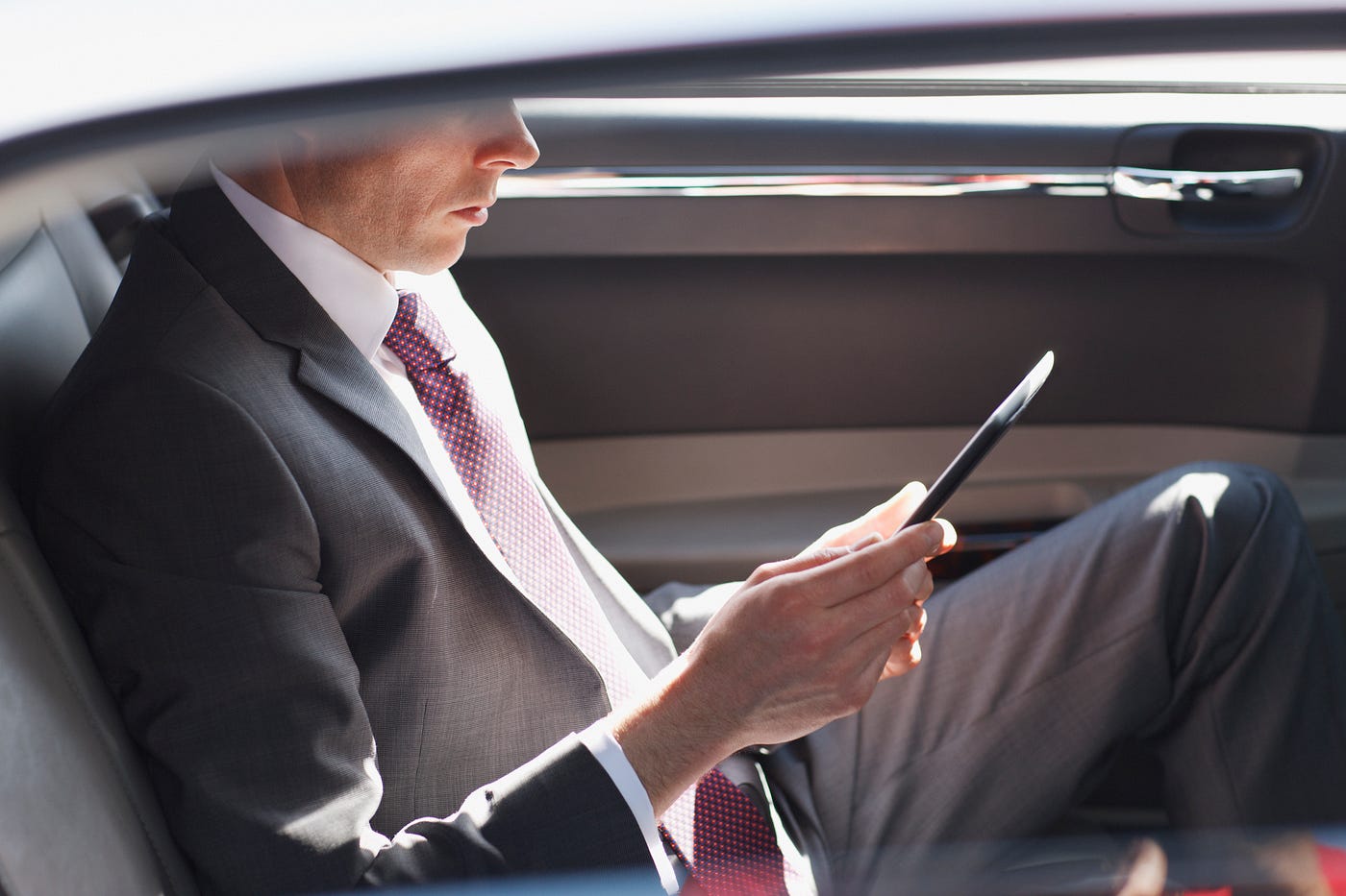 Professional chauffeur opening luxury car door for Newcastle to Sydney airport transfers service