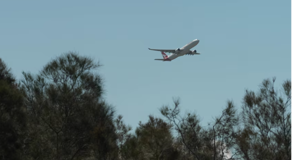 Brisbane Airport terminal with aircraft in the  air— Cars on Demand luxury airport transfer vehicles provide reliable ground transportation during flight path changes