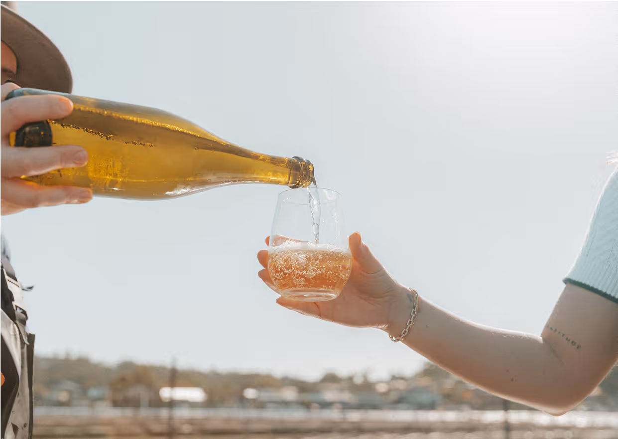 A bottle of champagne being poured into a circular glass