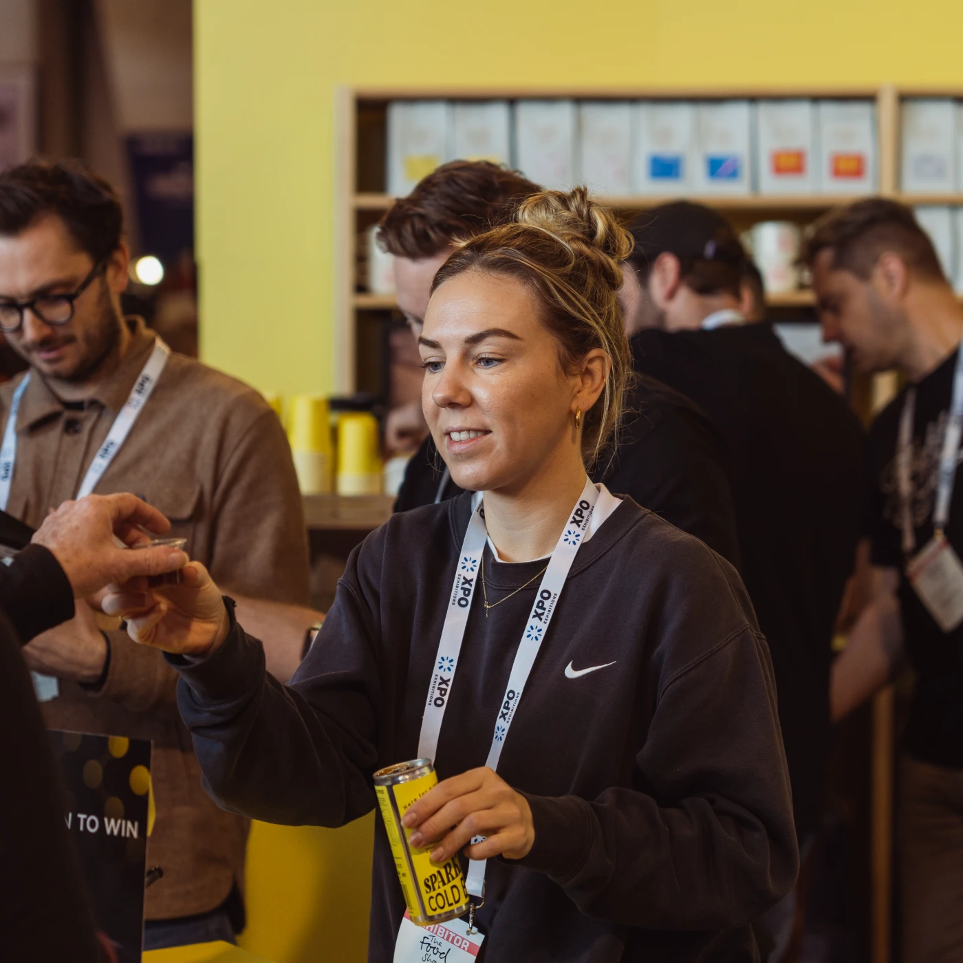 Flight Coffee brand ambassador sharing ready-to-drink coffee samples at a branded booth, engaging with customers at a coffee industry event.