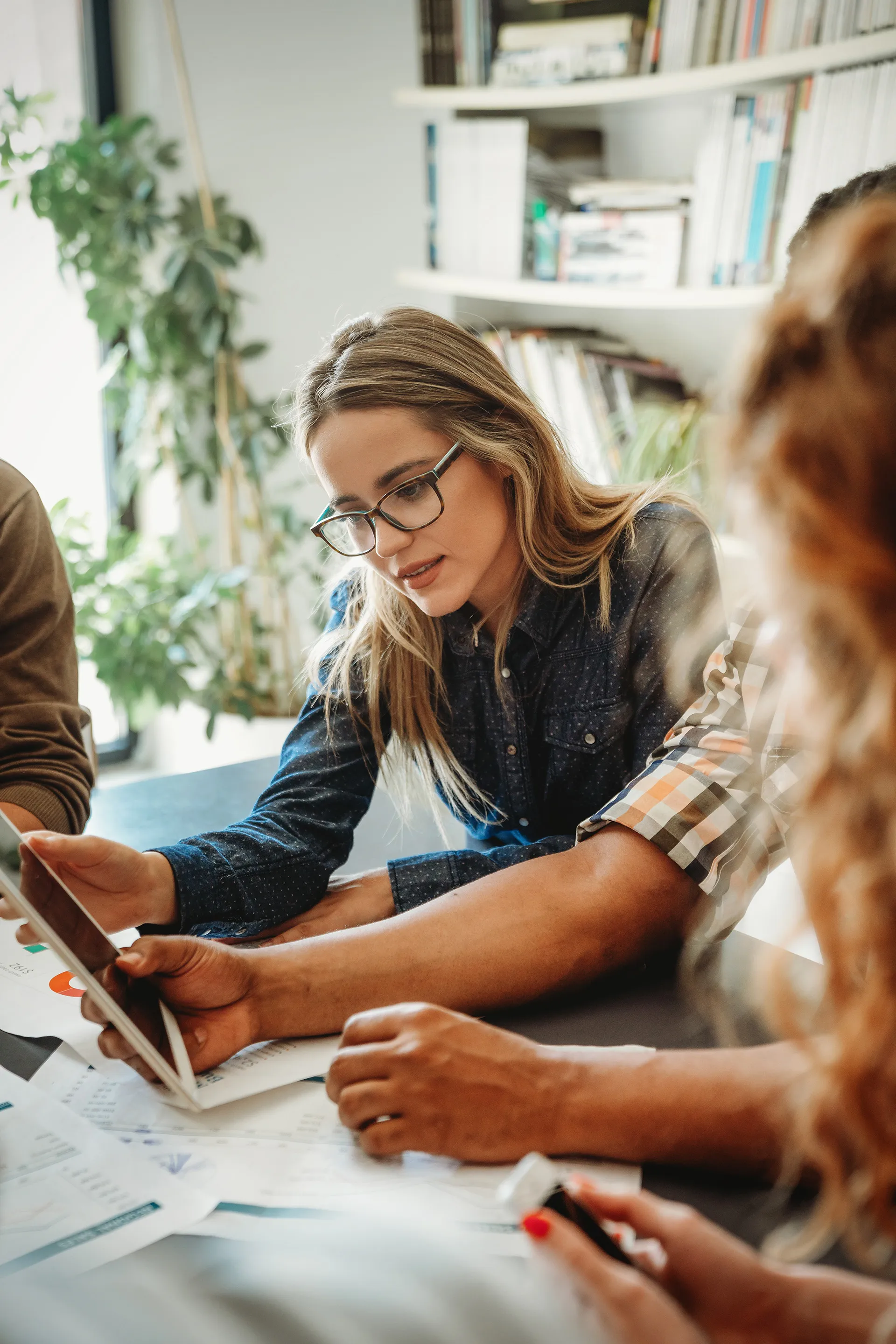 Two men and two women sitting together, openly discussing their workplace needs and working on tools to help them in the future.